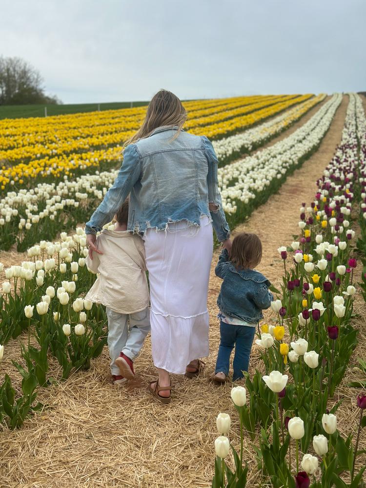 Danielle and her children walking through a tulip field